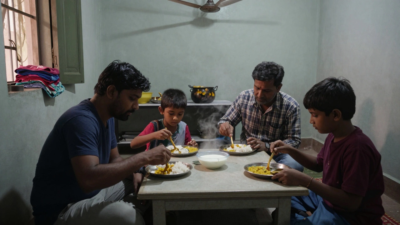 A family eating dinner on the floor with hands, plates of rice and dal in front of them.